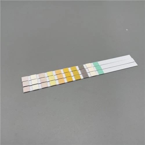 Mineral water test strips with multiple colored reagent pads arranged on a gray background
