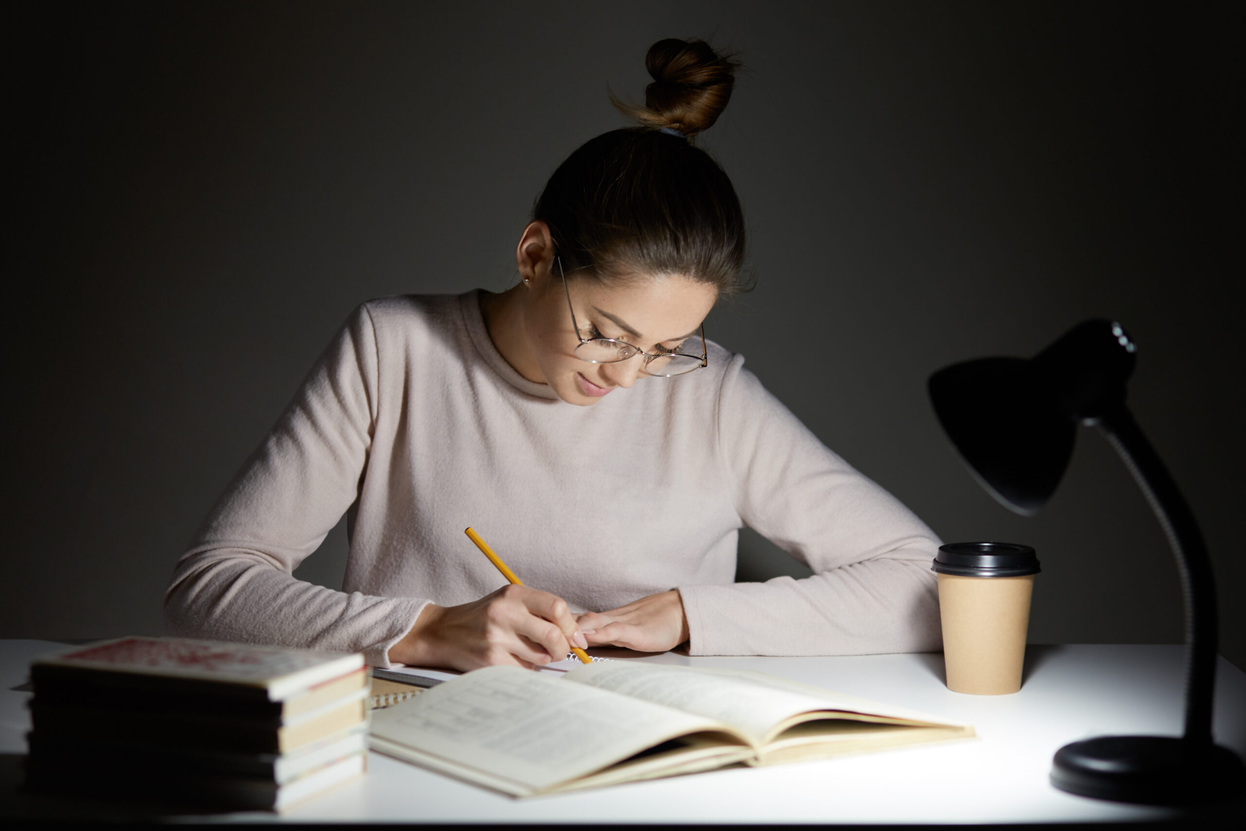 Woman writing in a notebook at a desk